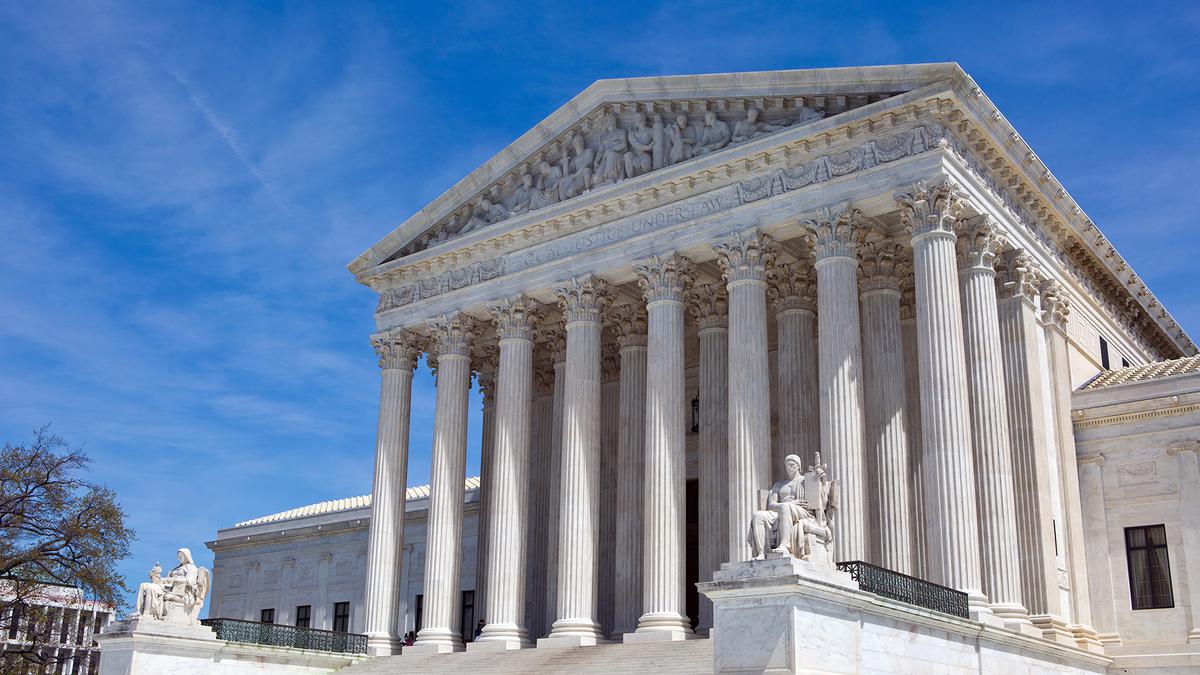 The U.S. Supreme Court building a blue sky behind it.